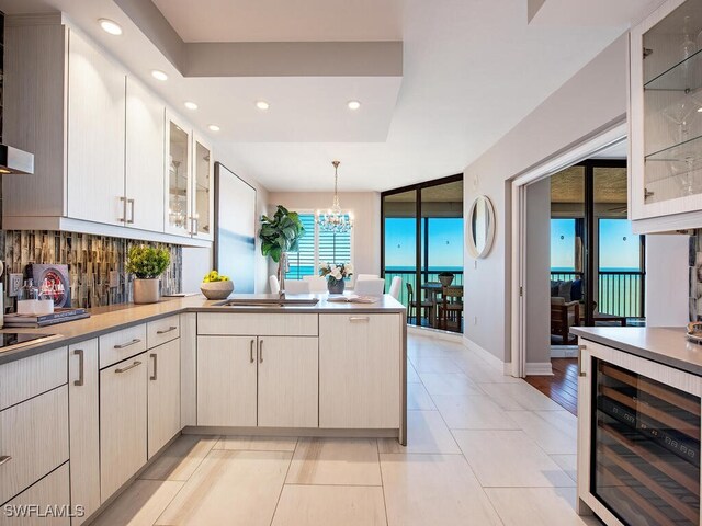 kitchen featuring decorative backsplash, sink, pendant lighting, light tile patterned floors, and wine cooler