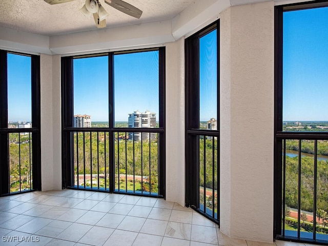 unfurnished sunroom with ceiling fan