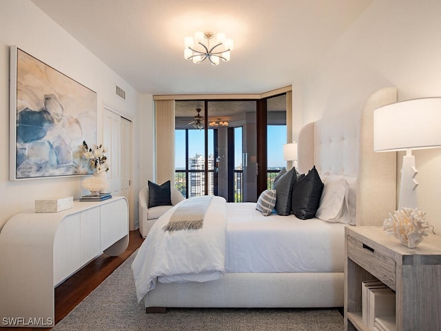 bedroom featuring floor to ceiling windows, an inviting chandelier, dark hardwood / wood-style flooring, access to outside, and a closet