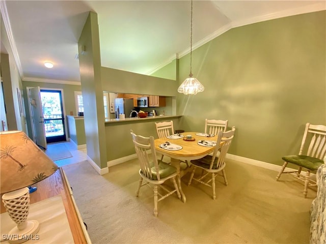 dining area with lofted ceiling, crown molding, and light carpet