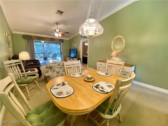 carpeted dining room featuring crown molding, vaulted ceiling, and ceiling fan