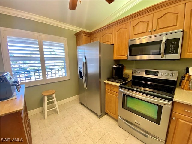 kitchen featuring ceiling fan, lofted ceiling, stainless steel appliances, and ornamental molding