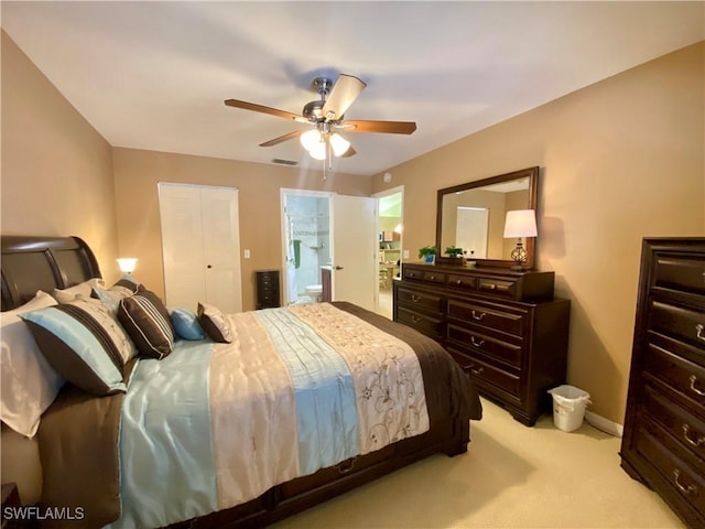 carpeted bedroom with ceiling fan, a closet, and ensuite bath