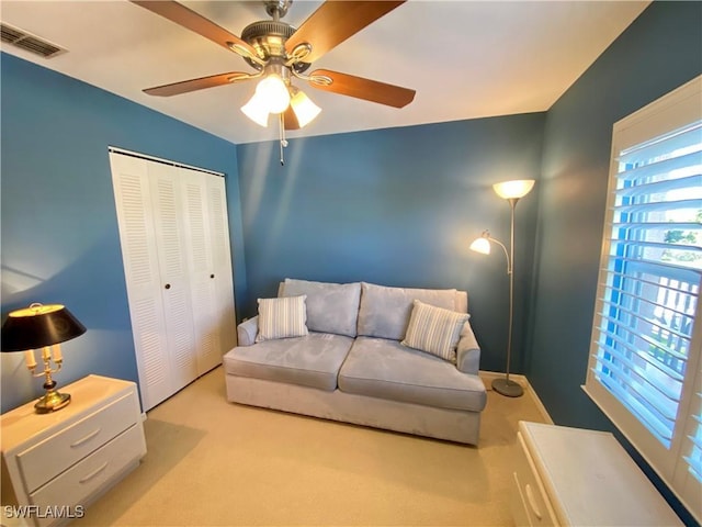 carpeted living room with ceiling fan