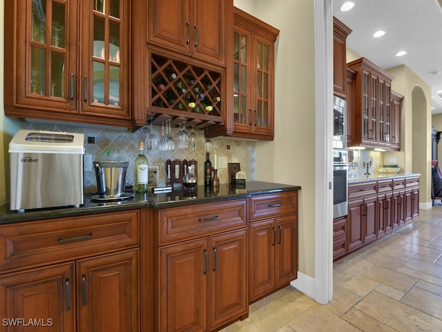 bar with stainless steel appliances, dark stone countertops, and tasteful backsplash