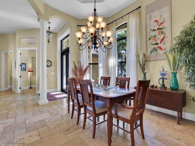 dining room with ornate columns and a chandelier