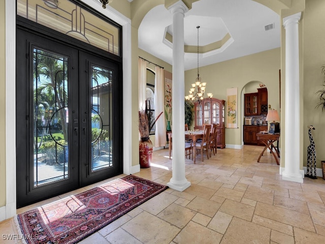 entryway with a chandelier, a healthy amount of sunlight, french doors, and a tray ceiling