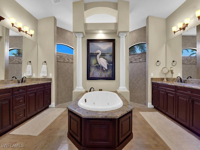 bathroom featuring decorative columns, a washtub, and vanity