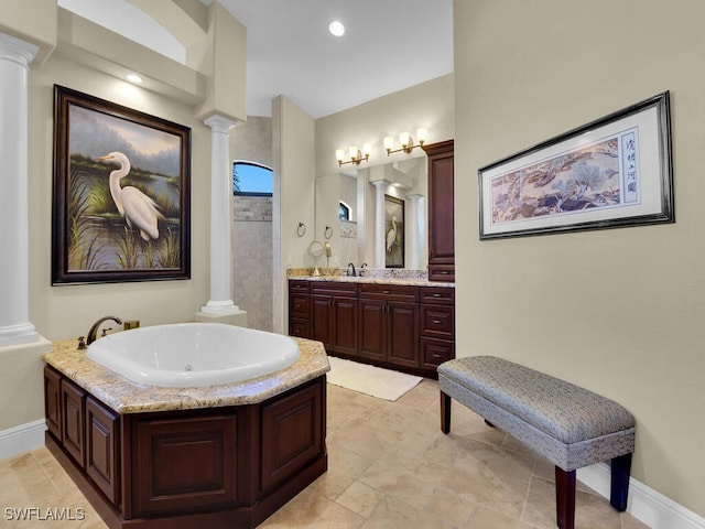 bathroom featuring a tub, vanity, and decorative columns