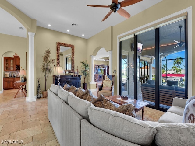 living room featuring ceiling fan and decorative columns