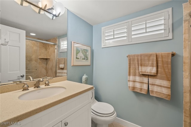 bathroom featuring toilet, vanity, and a shower with shower door