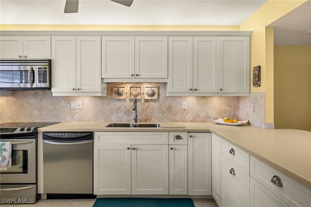 kitchen with white cabinetry, stainless steel appliances, sink, and decorative backsplash