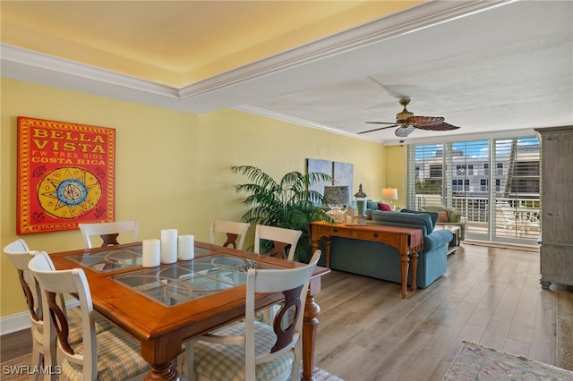 dining room with hardwood / wood-style floors, crown molding, expansive windows, and ceiling fan