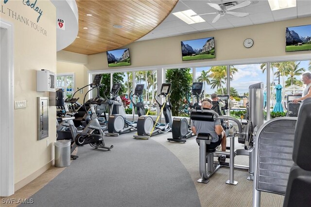 workout area with light colored carpet, ceiling fan, wooden ceiling, and plenty of natural light