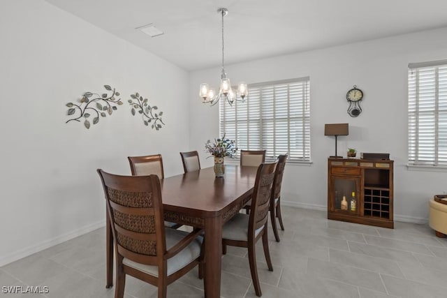 tiled dining room featuring a chandelier