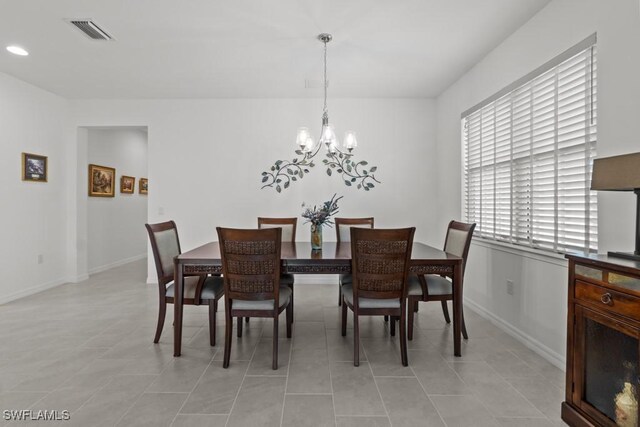 dining area with a notable chandelier and light tile patterned floors