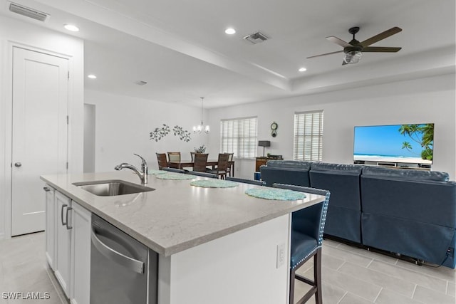 kitchen featuring dishwasher, a center island with sink, ceiling fan with notable chandelier, white cabinets, and sink