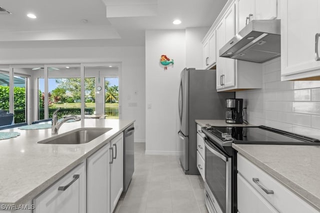 kitchen featuring appliances with stainless steel finishes, tasteful backsplash, sink, white cabinets, and exhaust hood