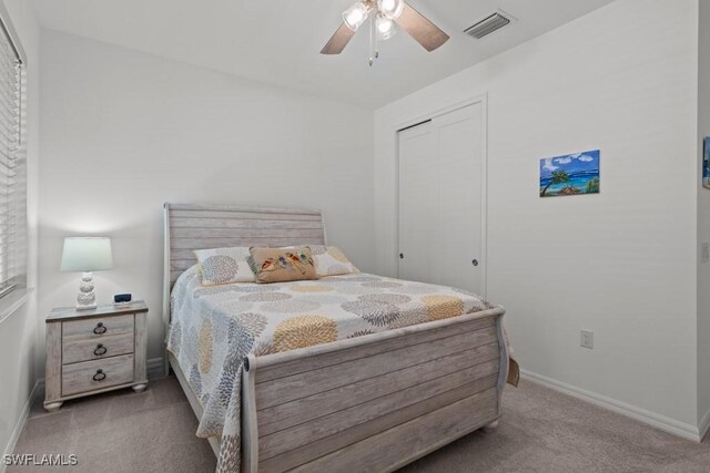 bedroom featuring ceiling fan, light colored carpet, and a closet