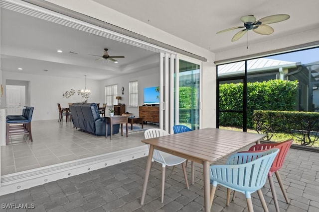 sunroom with ceiling fan with notable chandelier