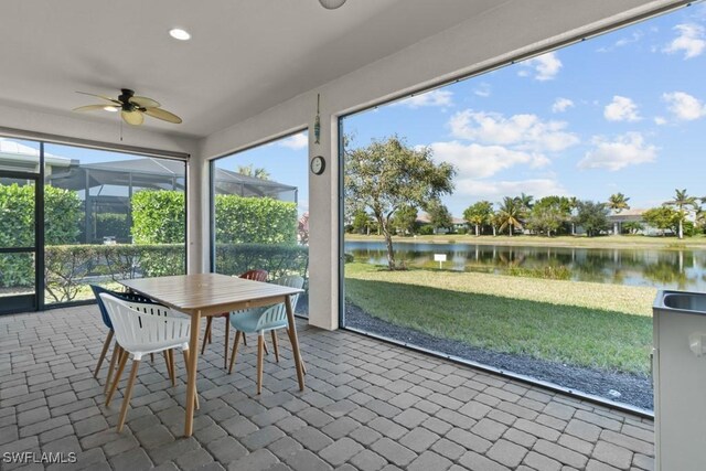 unfurnished sunroom with ceiling fan and a water view