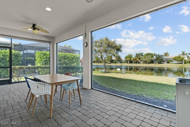 unfurnished sunroom with a water view and ceiling fan