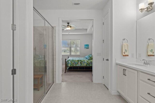 bathroom featuring ceiling fan, a shower with shower door, and vanity