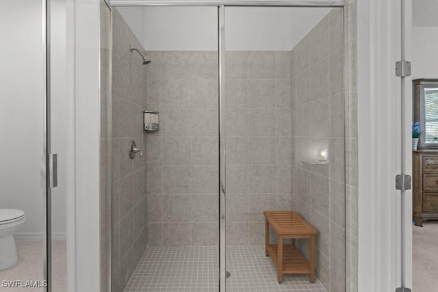 bathroom featuring tiled shower and toilet