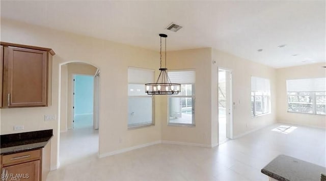 unfurnished dining area featuring a notable chandelier