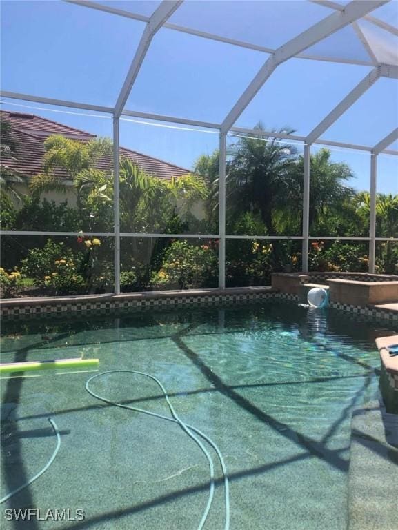 view of pool featuring glass enclosure