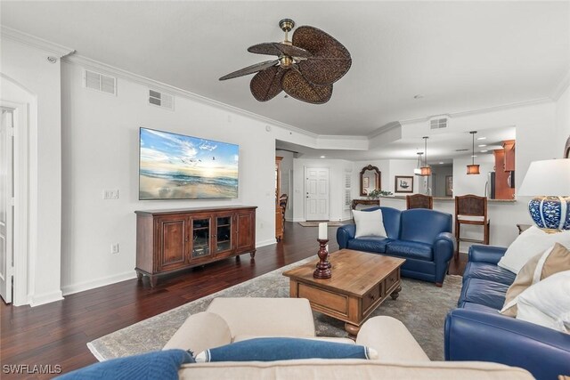 living room featuring ceiling fan, dark hardwood / wood-style floors, and ornamental molding