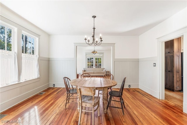 dining area with light wood-type flooring and a chandelier