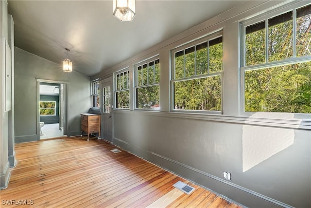 unfurnished sunroom with lofted ceiling