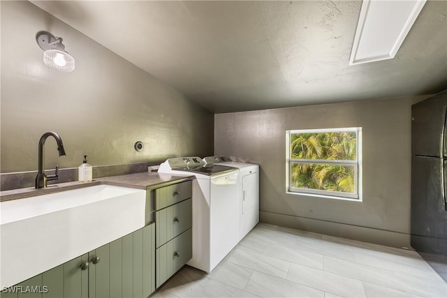 washroom featuring washer and clothes dryer, cabinets, and sink