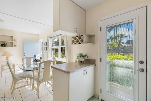 interior space with white cabinets and light tile patterned floors