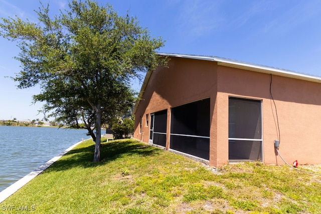 view of home's exterior featuring a lawn and a water view