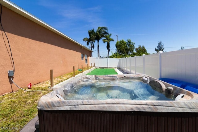 view of swimming pool with a hot tub