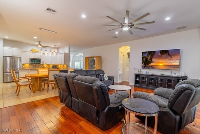 living room with ceiling fan and light wood-type flooring