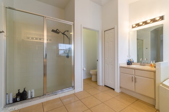 bathroom with tile patterned floors, vanity, toilet, and a shower with shower door