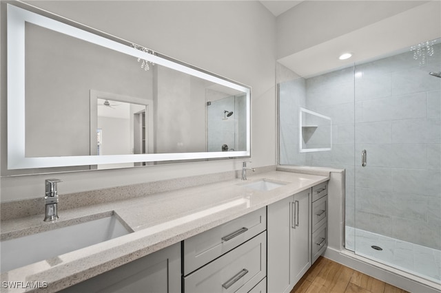 bathroom with vanity, ceiling fan, wood-type flooring, and a shower with shower door