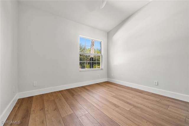 empty room with light hardwood / wood-style flooring and vaulted ceiling