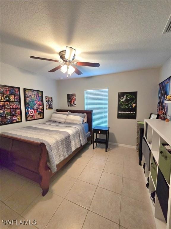 tiled bedroom featuring ceiling fan and a textured ceiling