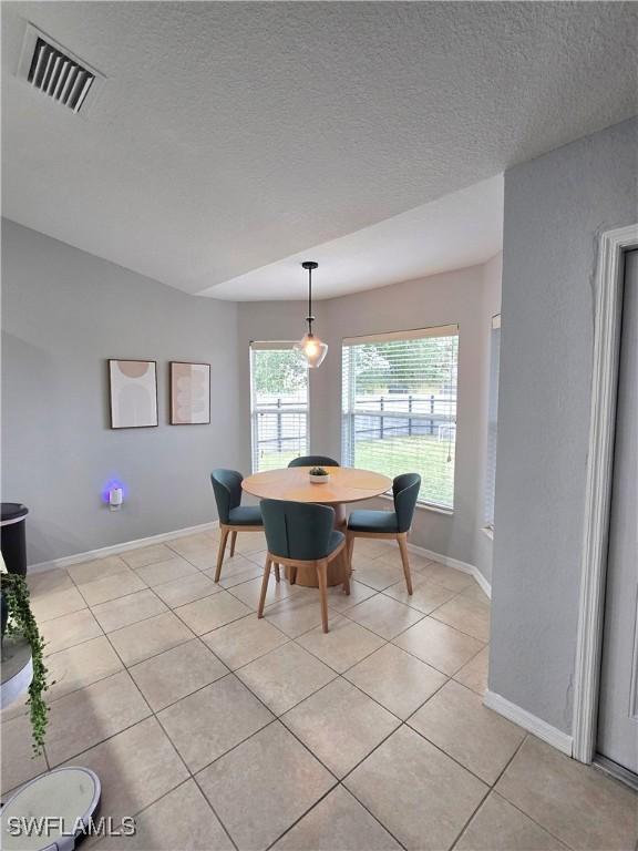 tiled dining area featuring a textured ceiling