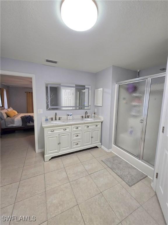 bathroom featuring vanity, a shower with door, and tile patterned flooring