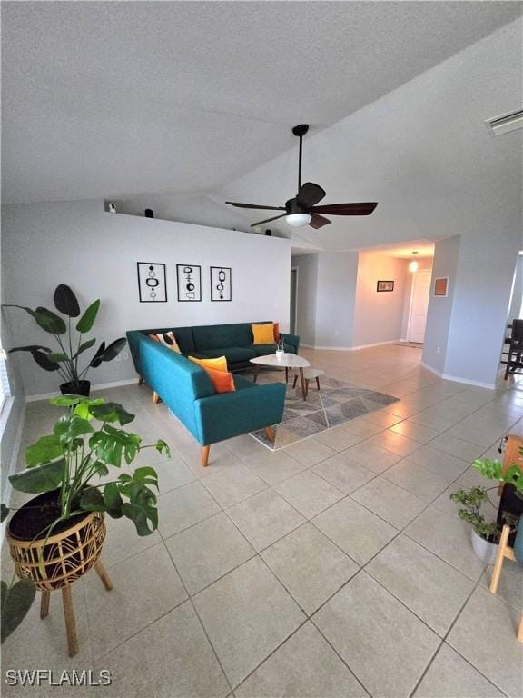 tiled living room featuring ceiling fan, a textured ceiling, and vaulted ceiling