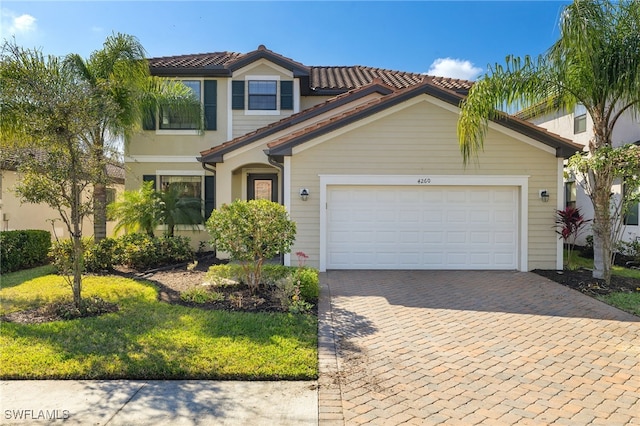 mediterranean / spanish-style house featuring a garage and a front lawn