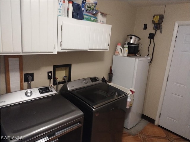 clothes washing area with cabinets, washer and dryer, and water heater