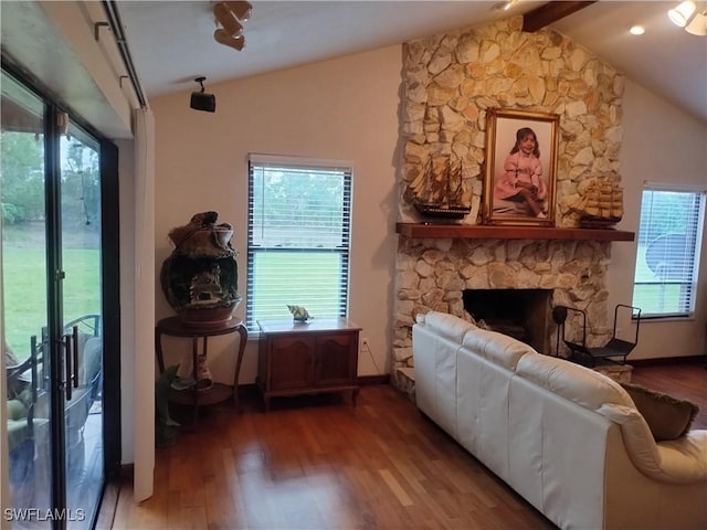 living room with lofted ceiling with beams, plenty of natural light, and a fireplace