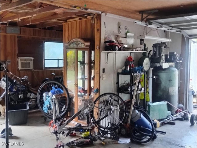 garage featuring a wall unit AC and wooden walls