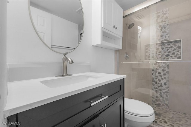 full bathroom featuring a stall shower, vanity, and toilet